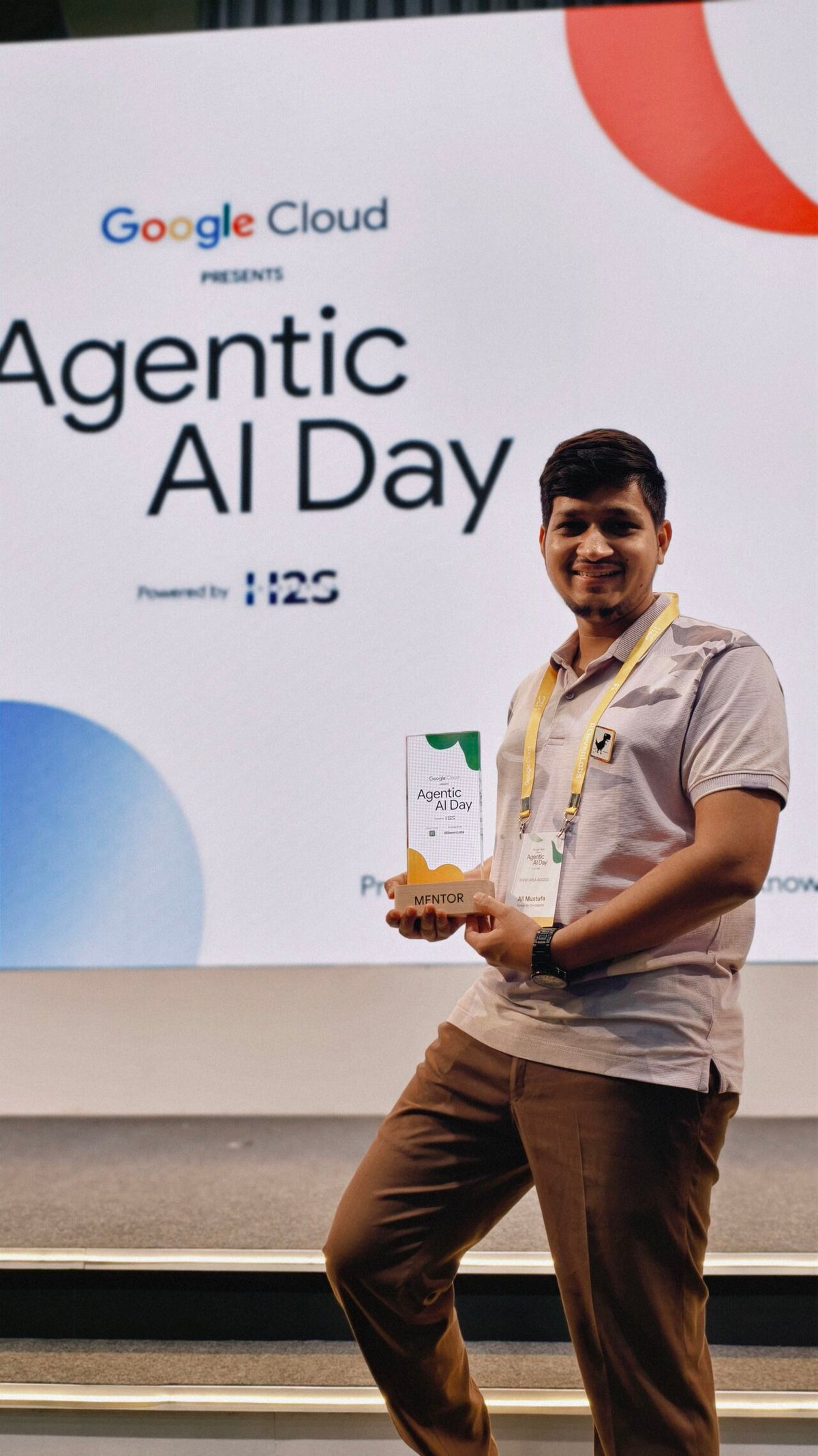 Ali Mustufa Shaikh holding a mentor trophy in front of the Agentic AI Day backdrop.