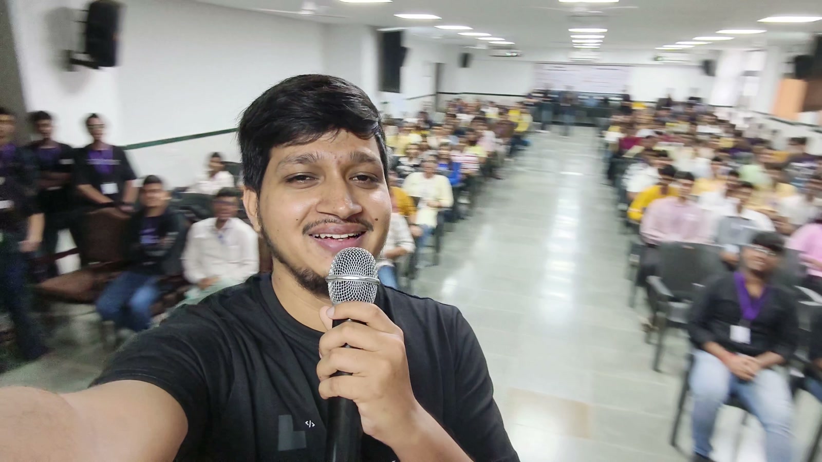 Ali Mustufa Shaikh holding a microphone with the GenAI 101 workshop audience at A. P. Shah Institute of Technology (APSIT) in Thane, Maharashtra.